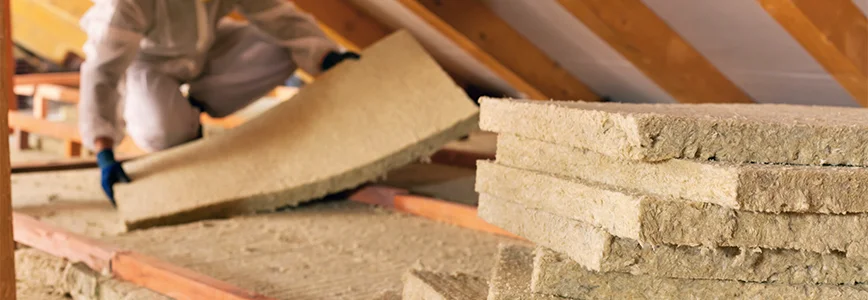 Person dämmt einen Dachboden